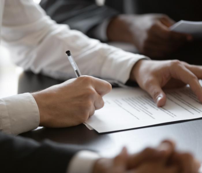 person filling out paperwork with a pen
